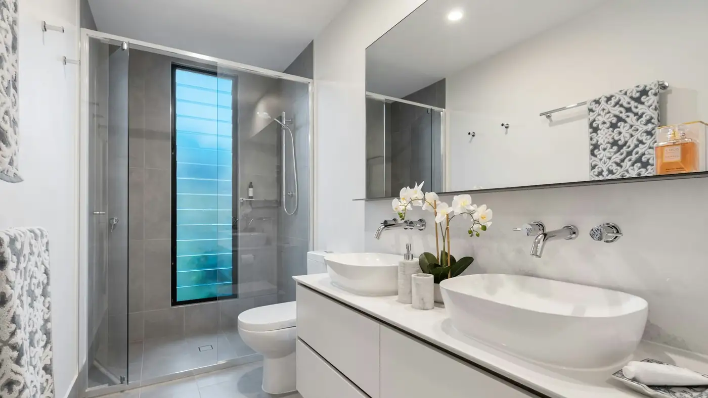 Renovated bathroom with a double vanity and tiled walls