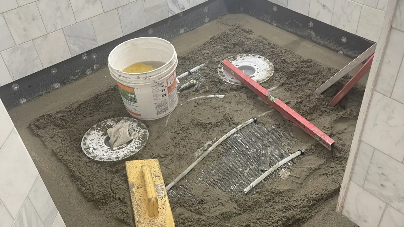 Mortar bed floated by hand across a bathroom floor